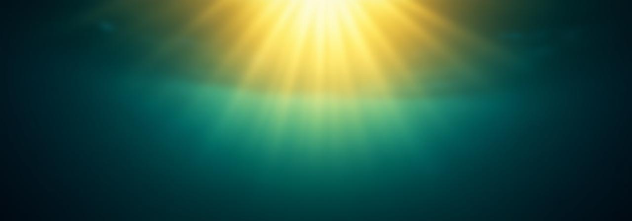 Golden sunlight filtering through deep blue ocean water